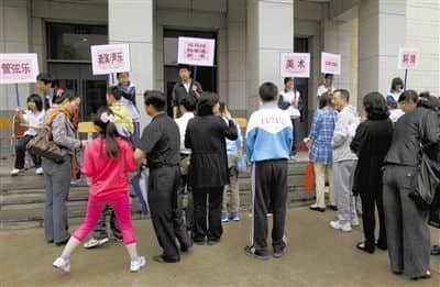 2012年5月12日，一中学门口，报名“小升初”的家长和孩子在排队，准备测试特长。新京报资料图片