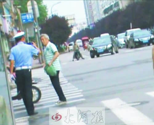 洛阳协警没看到电动车闯红灯 遭老人辱骂吐口水